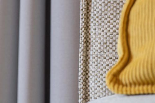 a close up of a table with a yellow chair at Biohotel Gralhof in Weissensee