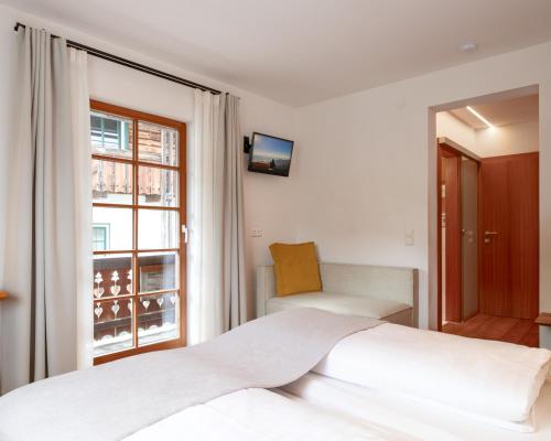 a bedroom with a bed and a window at Biohotel Gralhof in Weissensee