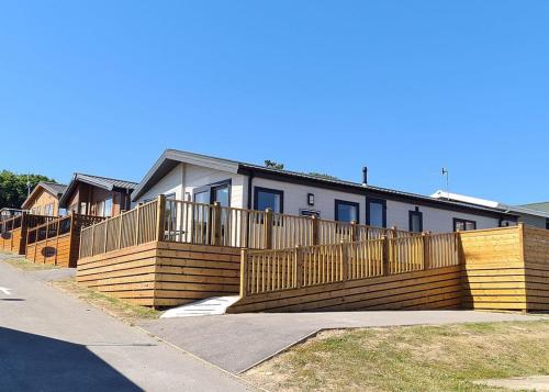 a wooden fence in front of a house at Shear Barn Holiday Park in Hastings