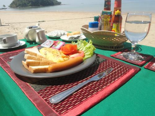 une assiette de nourriture sur une table sur la plage dans l'établissement Vacation House, à Klong Muang Beach