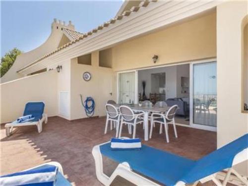 ein Haus mit einer Terrasse mit Tisch und Stühlen in der Unterkunft La Manga Club Resort - Los Olivos 417 in Atamaría