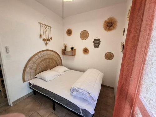 a bed with two pillows on it in a room at Rez de jardin climatisé avec grande terrasse in Gruissan