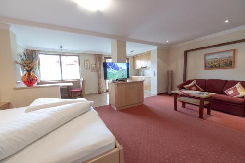 a hotel room with a bed and a living room at Frühstückshotel Margret in Maurach