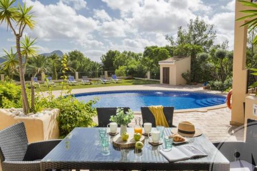 patio ze stołem i krzesłami przy basenie w obiekcie La Manga Club Resort - Individual Villa 559 w mieście Atamaría