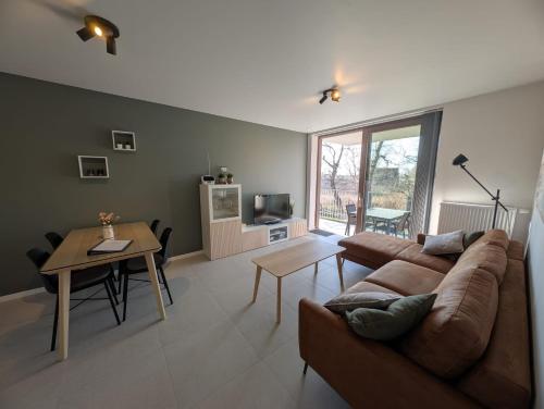 a living room with a couch and a table at Vakantieappartement West Bay Westende in Middelkerke