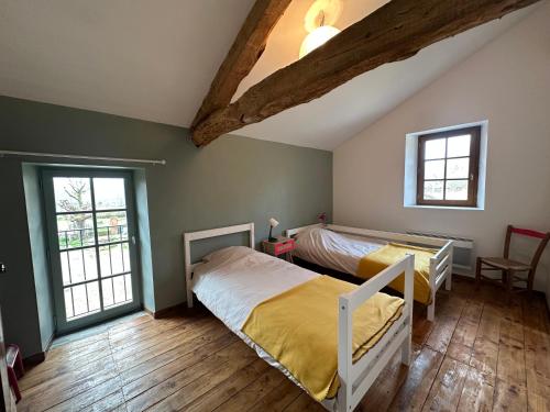 une chambre avec deux lits et deux fenêtres dans l'établissement Gîte à la Ferme de Verdurette Cordes-sur-Ciel, à Cordes-sur-Ciel