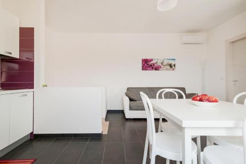 a kitchen and dining room with a white table and chairs at Salentipity in Marina di Pescoluse
