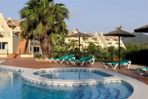 einen Pool mit Stühlen und Sonnenschirmen in einem Resort in der Unterkunft La Manga Club Resort - Los Olivos 494 in Atamaría