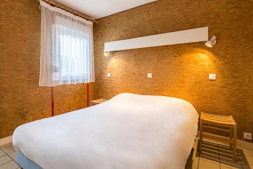 a bedroom with a white bed and a window at Azureva Murol in Murol