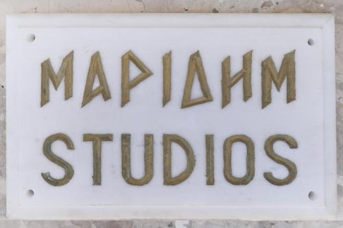 a sign that reads marian studios on a wall at Maridim studios in Ermoupoli