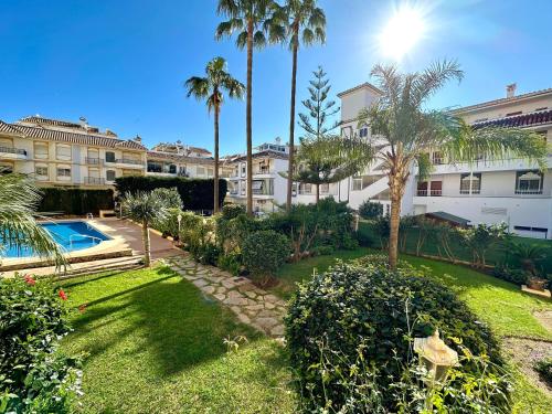 an apartment complex with palm trees and a yard at Sunset Vibes Mijas in La Cala de Mijas