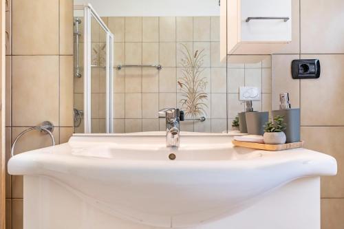 a bathroom with a white sink and a shower at Agritur Laura in Nago-Torbole