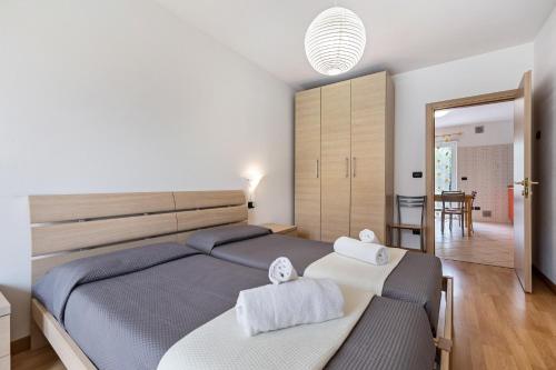 a bedroom with a large bed with towels on it at Agritur Laura in Nago-Torbole