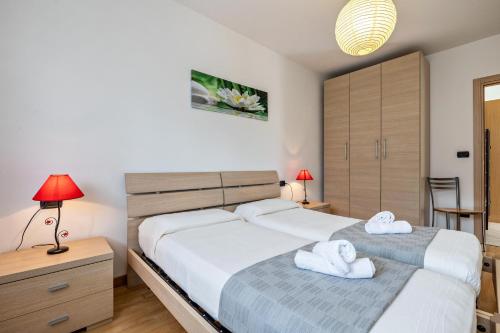 two beds in a bedroom with two towels at Agritur Laura in Nago-Torbole
