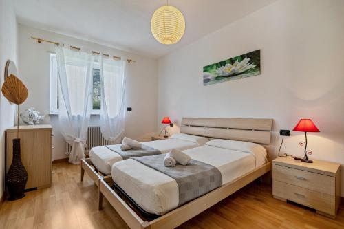 a bedroom with two beds and two windows at Agritur Laura in Nago-Torbole