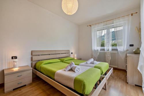 a bedroom with two beds and a window at Agritur Laura in Nago-Torbole