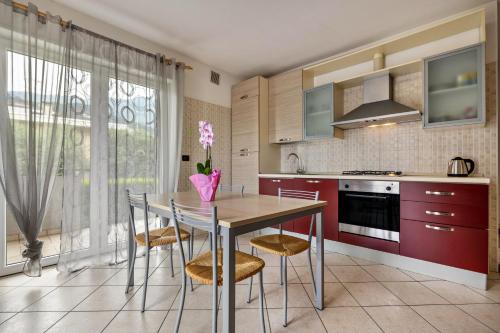 a kitchen with a table with chairs and a vase at Agritur Laura in Nago-Torbole