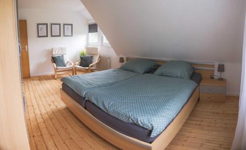 Un dormitorio con una cama grande con sábanas azules. en Bei Fuchses am Wisentpfad, en Bad Berleburg
