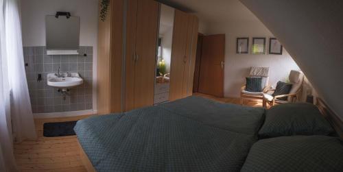 Un dormitorio con una cama y un lavabo en una habitación. en Bei Fuchses am Wisentpfad, en Bad Berleburg