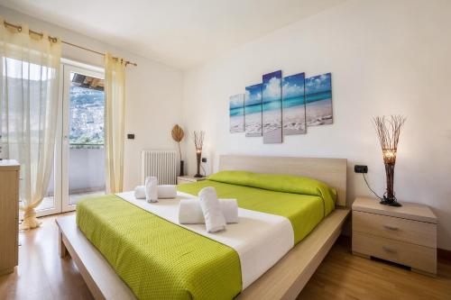 a bedroom with a green and white bed and a window at Agritur Laura in Nago-Torbole