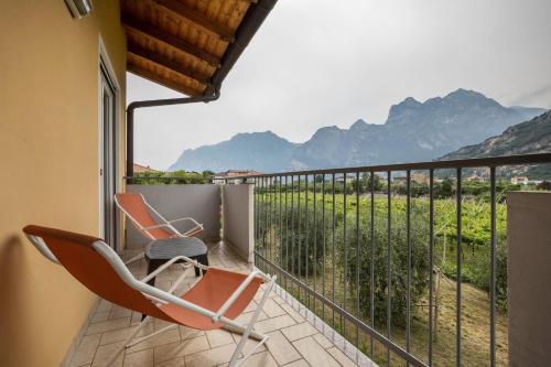 a balcony with two chairs and a view of mountains at Agritur Laura in Nago-Torbole