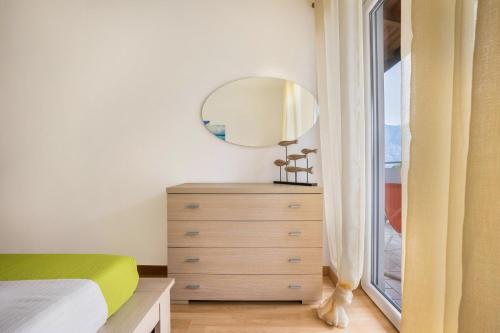 a bedroom with a bed and a mirror on a dresser at Agritur Laura in Nago-Torbole