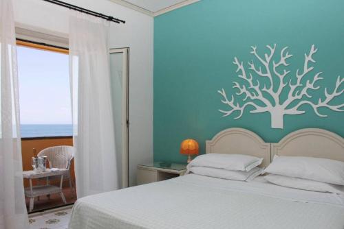 a bedroom with a bed with a tree on the wall at Sunbay Park Hotel in Civitavecchia