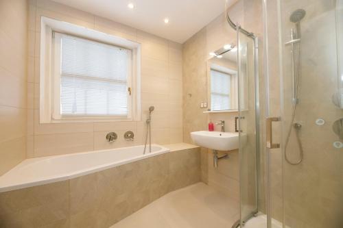 a bathroom with a tub and a sink and a shower at Aparthotel Panorama in Deštné v Orlických horách