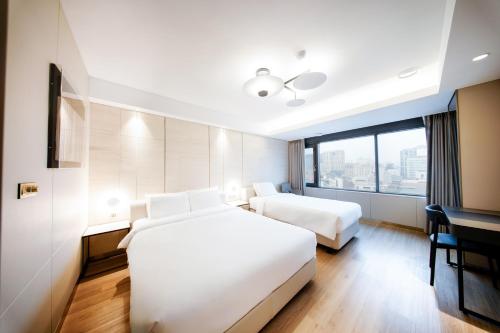 a hotel room with two beds and a window at Eliena Hotel Seoul Gangnam in Seoul