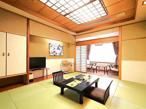 a living room with a table and a television at LiVEMAX Resort Izu Kogen Terrace & Spa in Ito