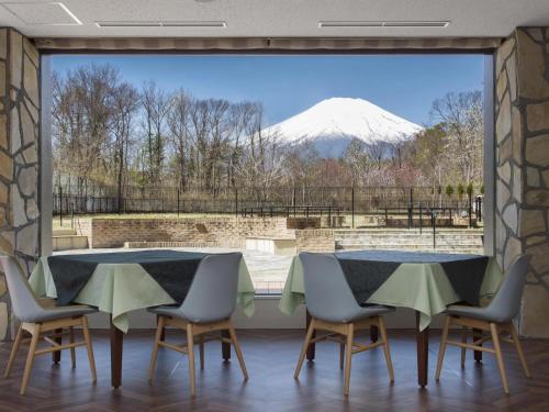 a dining room with a view of a snow covered mountain at Wan's Resort Yamanakako in Yamanakako
