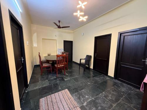 a dining room with a table and chairs and a ceiling fan at Bluebell Home in Kozhikode