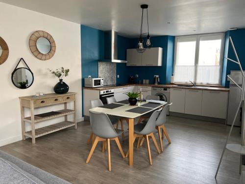 une cuisine avec une table et des chaises dans une pièce dans l'établissement St Georges d'Oléron maison de village, à Saint-Georges-dʼOléron