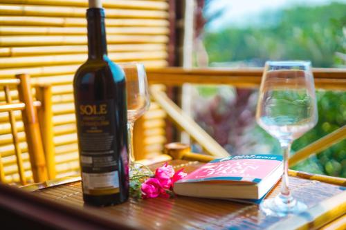 a bottle of wine and two glasses on a table at HDT Farm Stay Thanh Chuong in Thái Nhã