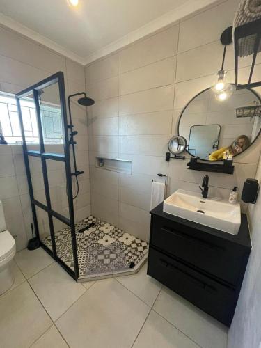 a bathroom with a shower and a sink and a mirror at Lesame getaway in Tlokweng