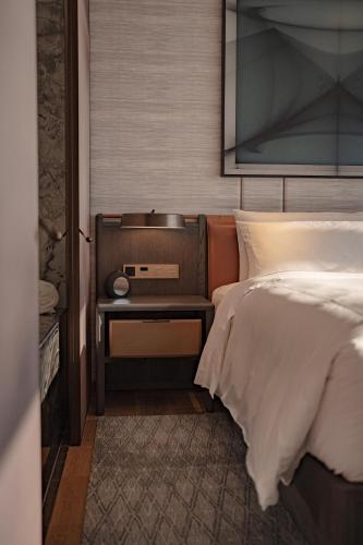 a bedroom with a bed and a side table at Conrad Shenzhen, the first art museum hotel in Greater Bay Area with the stunning bay and sunset view in the hotel terrace in Shenzhen