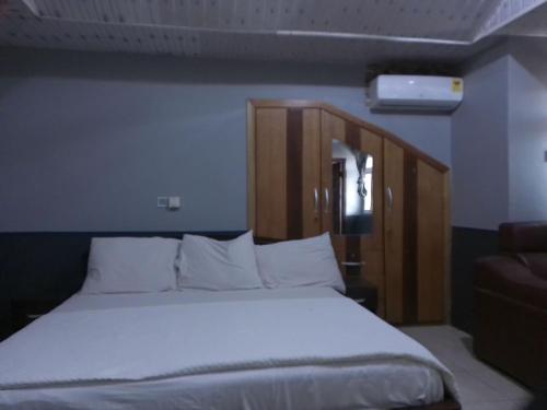 a bed with white sheets and pillows in a room at Great Escape Inn Hotel in Bortianor