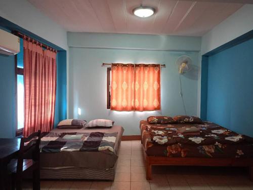 a bedroom with two beds and a window at Baan Picha 2 in Pattaya