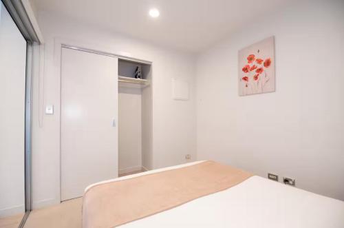 a bedroom with a bed and a sliding door at 180 Degrees Seaview and Harbor View 2 bedroom Apartment in Auckland