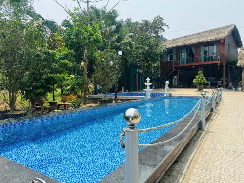 ein Swimmingpool mit Zaun und Gebäude in der Unterkunft Hue Panorama Villa in Cư Chinh