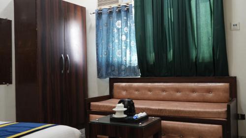 a bedroom with a bed and a table with a night stand at Golden GSC Hotel in Amritsar