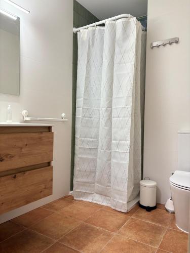 a bathroom with a shower curtain and a toilet at Casa Gregal CR Los Cuatro Vientos in Moratalla
