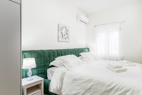 a bedroom with two white beds and a green headboard at Villa Irene Royale - Pool - Sea View - Free Cruise in Tigaki