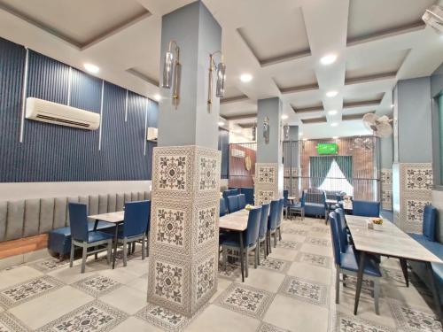 a dining room with blue chairs and tables at Golden GSC Hotel in Amritsar