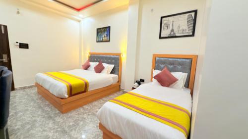 a hotel room with two beds in it at Golden GSC Hotel in Amritsar