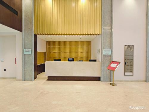 a lobby with a reception desk in a building at Ramada by Wyndham Ahmedabad Narendra Modi Stadium Motera in Ahmedabad