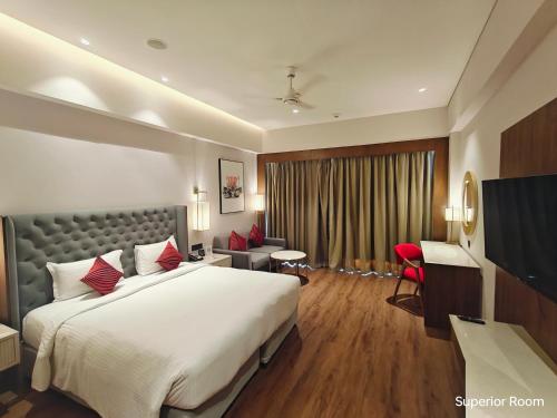 a hotel room with a large bed and a desk at Ramada by Wyndham Ahmedabad Narendra Modi Stadium Motera in Ahmedabad