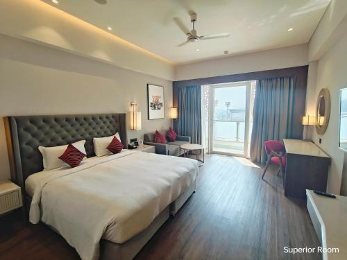 a hotel room with a large bed and a window at Ramada by Wyndham Ahmedabad Narendra Modi Stadium Motera in Ahmedabad