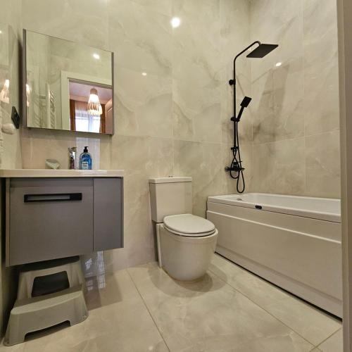 a bathroom with a toilet and a sink and a bath tub at Niabi 3BDR Villa with pool in Tbilisi City
