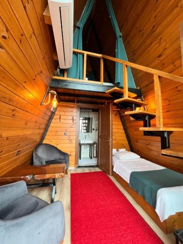 a attic room with two beds and a red carpet at Loya Butik Otel Bungalov in Rize